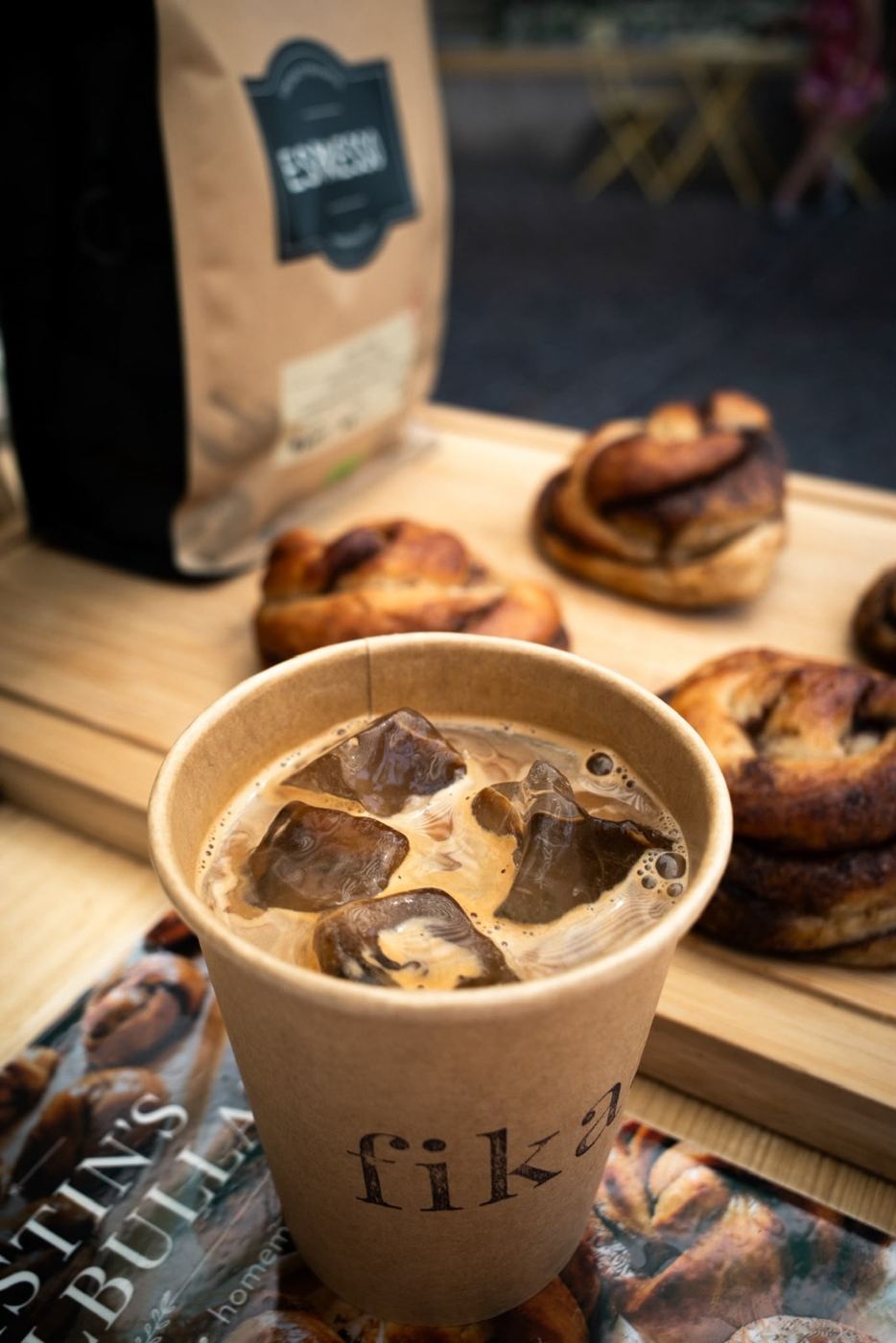 Iced Coffee in einem fika.-Becher mit Zimtschnecken