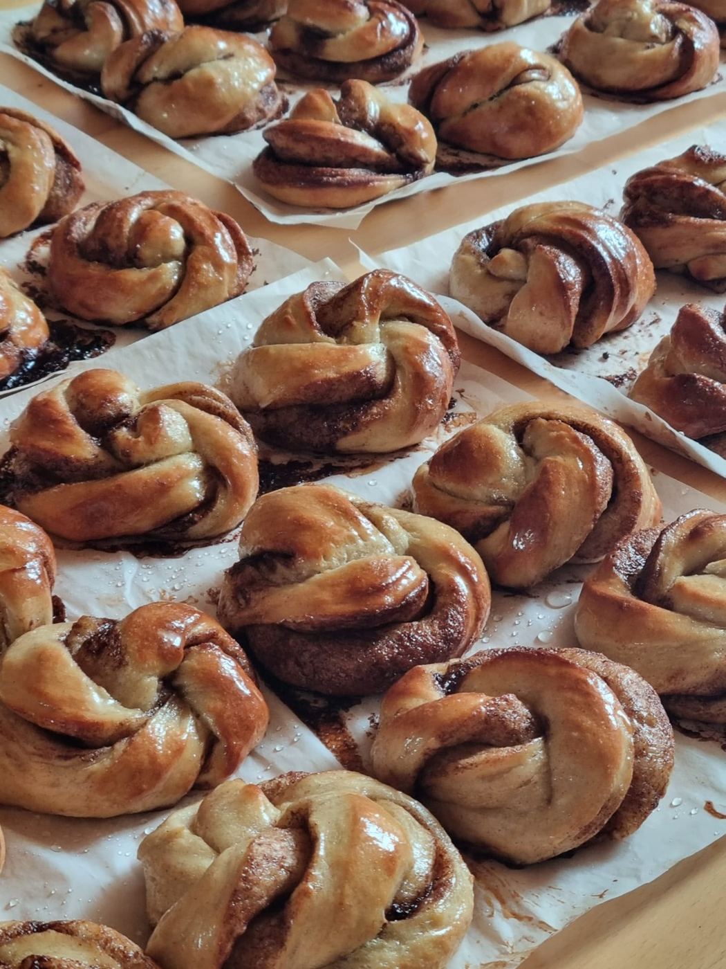 Frisch gebackene Kanelbullar auf Backpapier